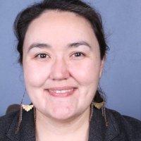 Headshot of Frieda McAlear, an Indigenous woman with brown hair and dangling earrings.