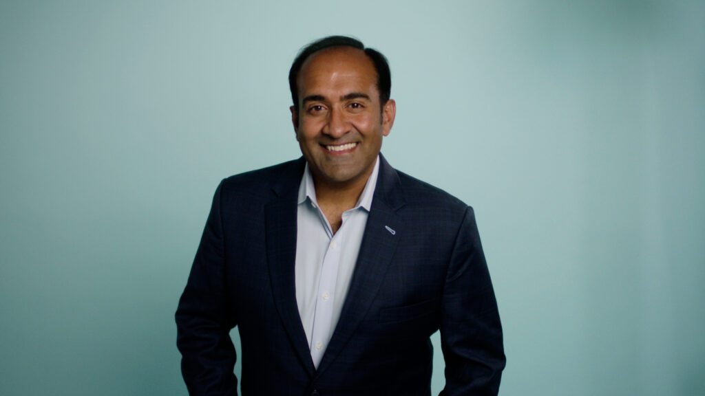 Headshot of Rohit Bhargava, an Indian-American male in his mid-40s with black hair and a white shirt paired with a navy blue suit